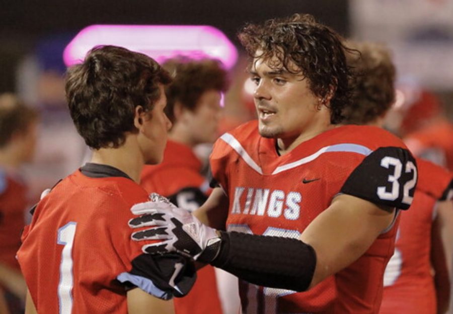 Gabe Hicks coaches up a younger player on the sideline