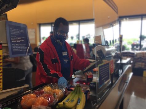 Othello Gooden Jr., essential worker at Kroger, checks out customers using PPE.