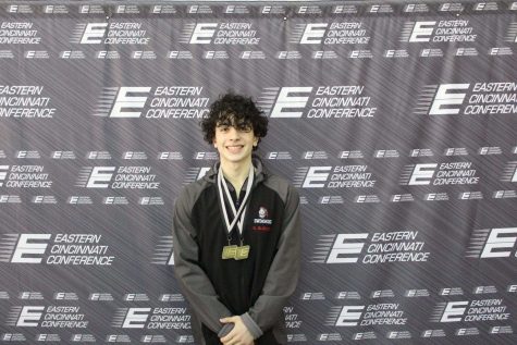 Kevin Glennon shows off his two medals after he just earned first place in the 100 fly and backstroke in the conference