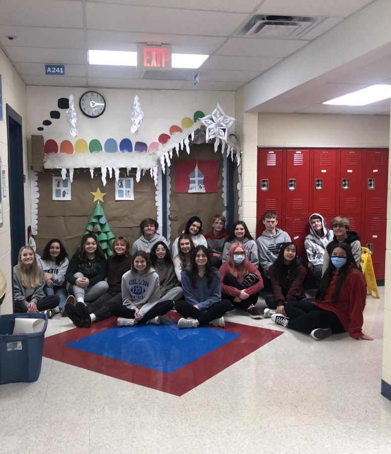 The winning class sitting in front of their decorated door