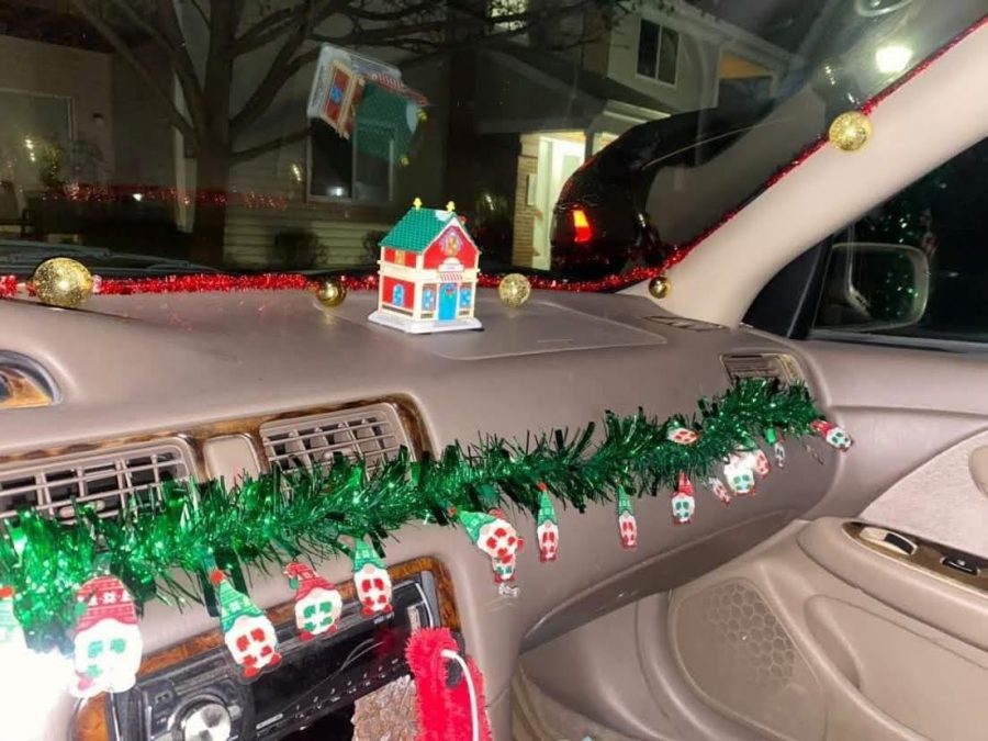  Christmas decor envelops the dashboard of Karmen Kirker’s car with tinsel, ornaments, elves, and a small plastic house