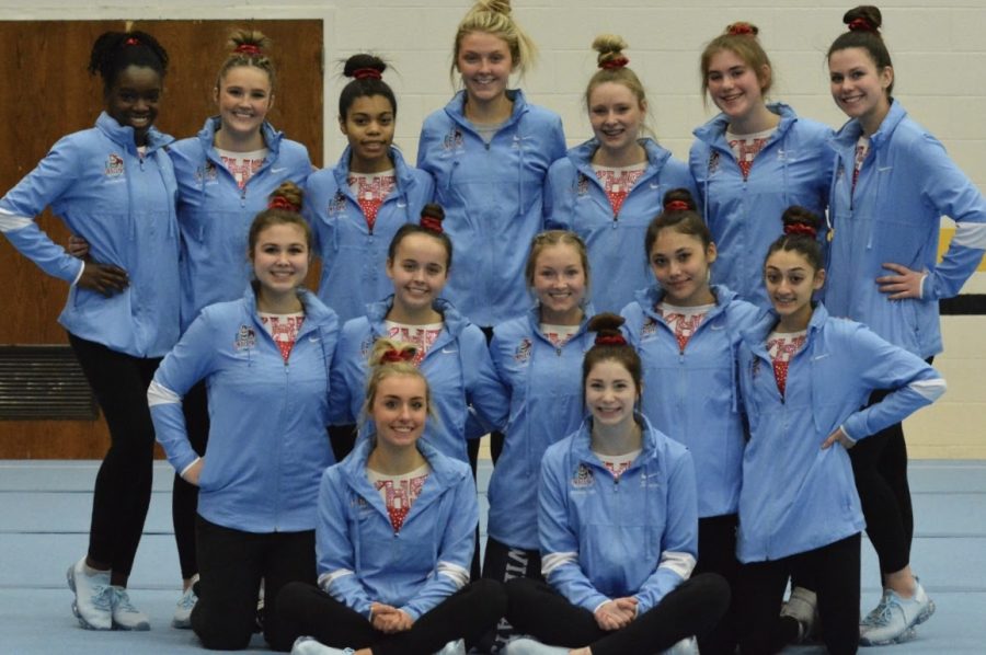Gymnastics team takes a team picture after competing at Anderson 