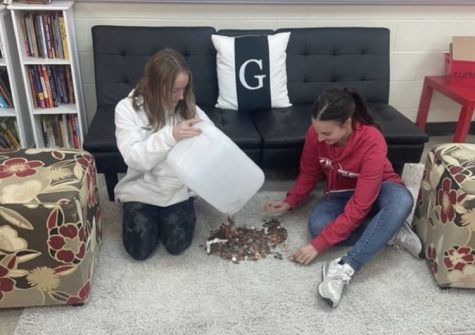 Avery Tumler and Katlyn Gilbert prepare to count coins, collected from the first ever Spooktacular Coin Drive.