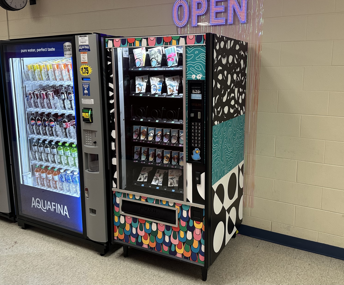 The new DMA vending machine sits next to the two drink vending machines in the main intersection, offering an assortment of art pieces for students to buy. Photo Credit: Jorie Allison